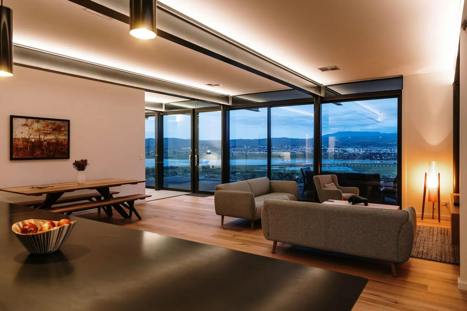 Interior cálido con grandes ventanales y vista al exterior